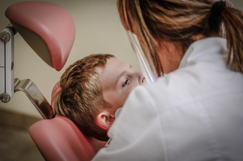 dentist examines a little boy in a dentist chair