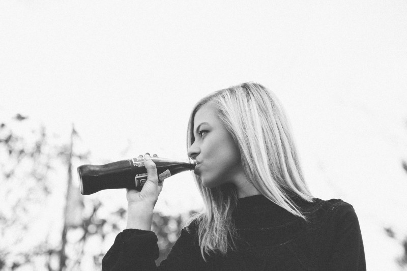 Woman drinking a coke in black and white