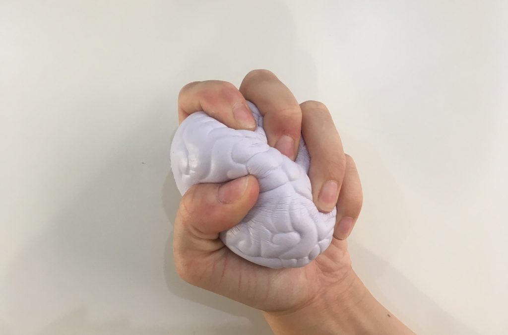 a hand squeezes a foam stress ball